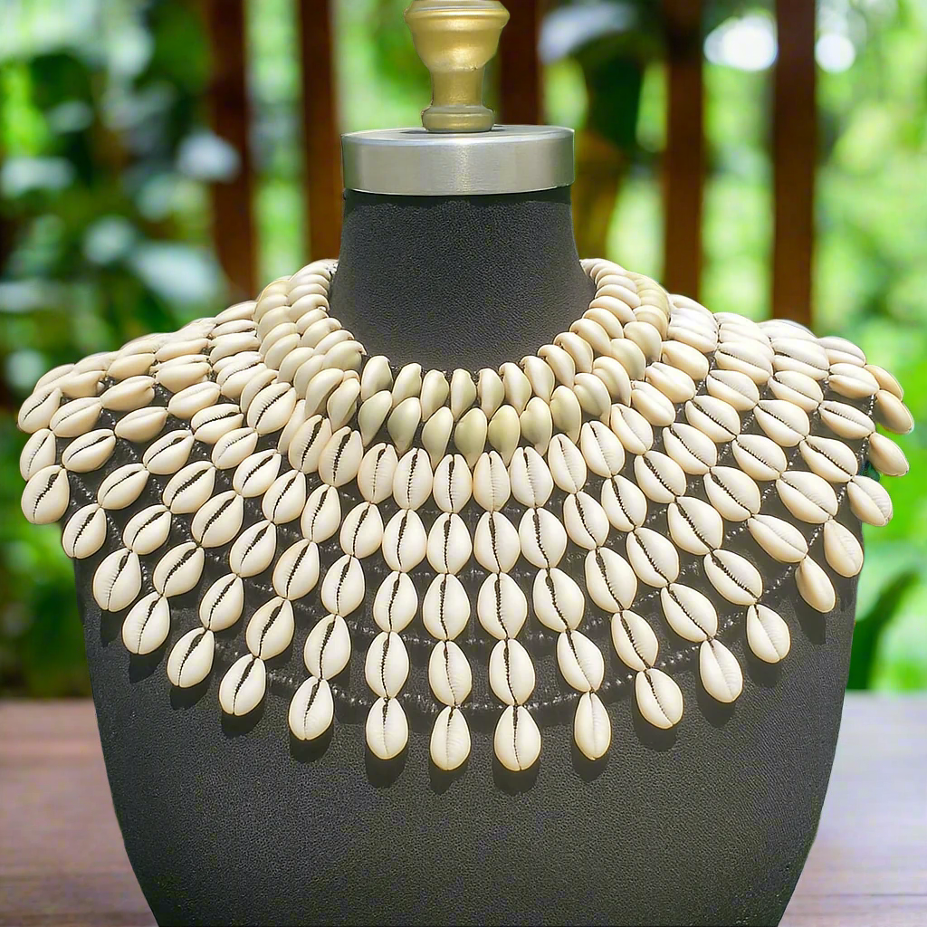 Necklace made of cowrie shell on a mannequin against a blurred green background