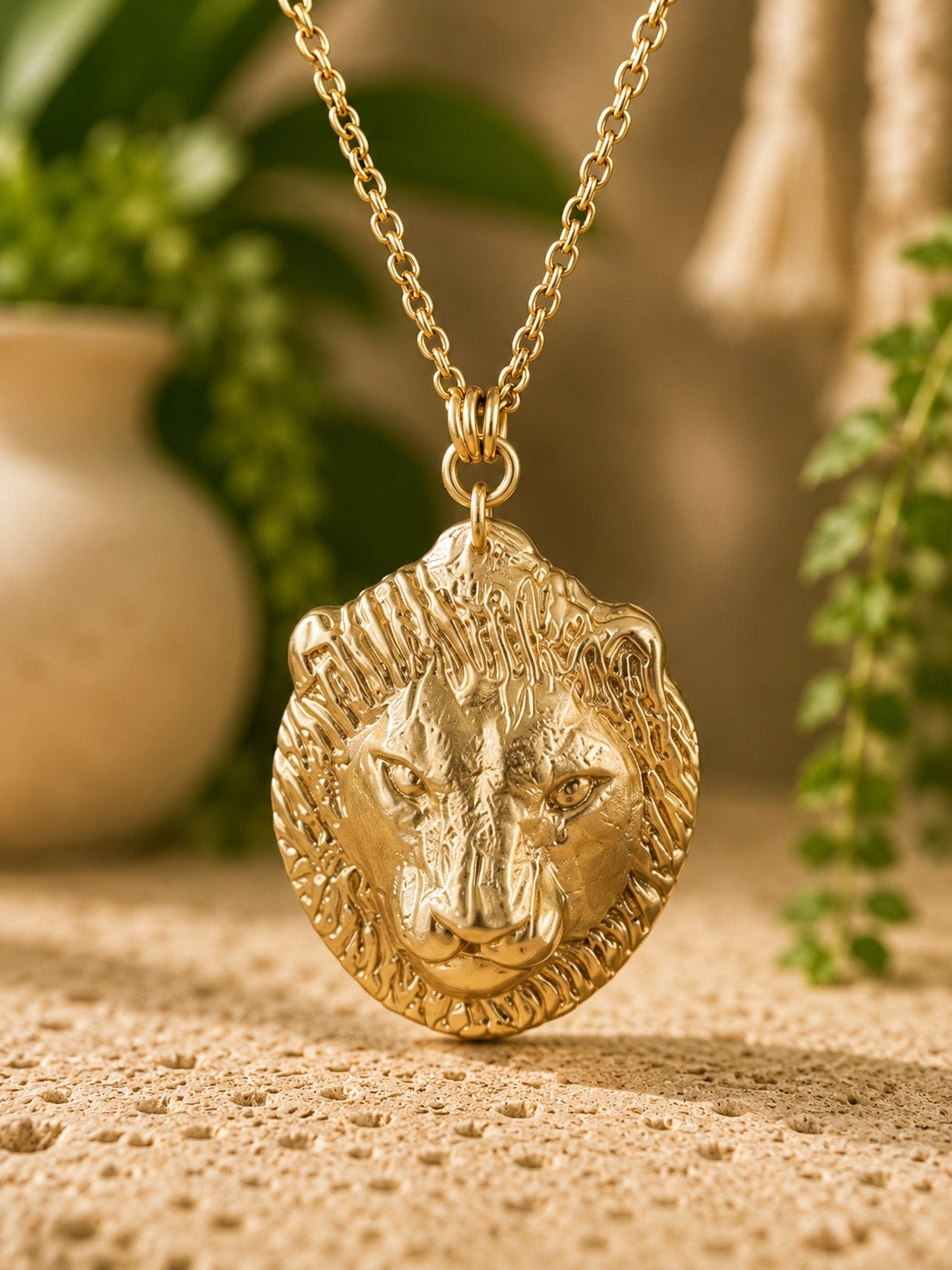 brass lion head pendant necklace on a brass chain with a natural background