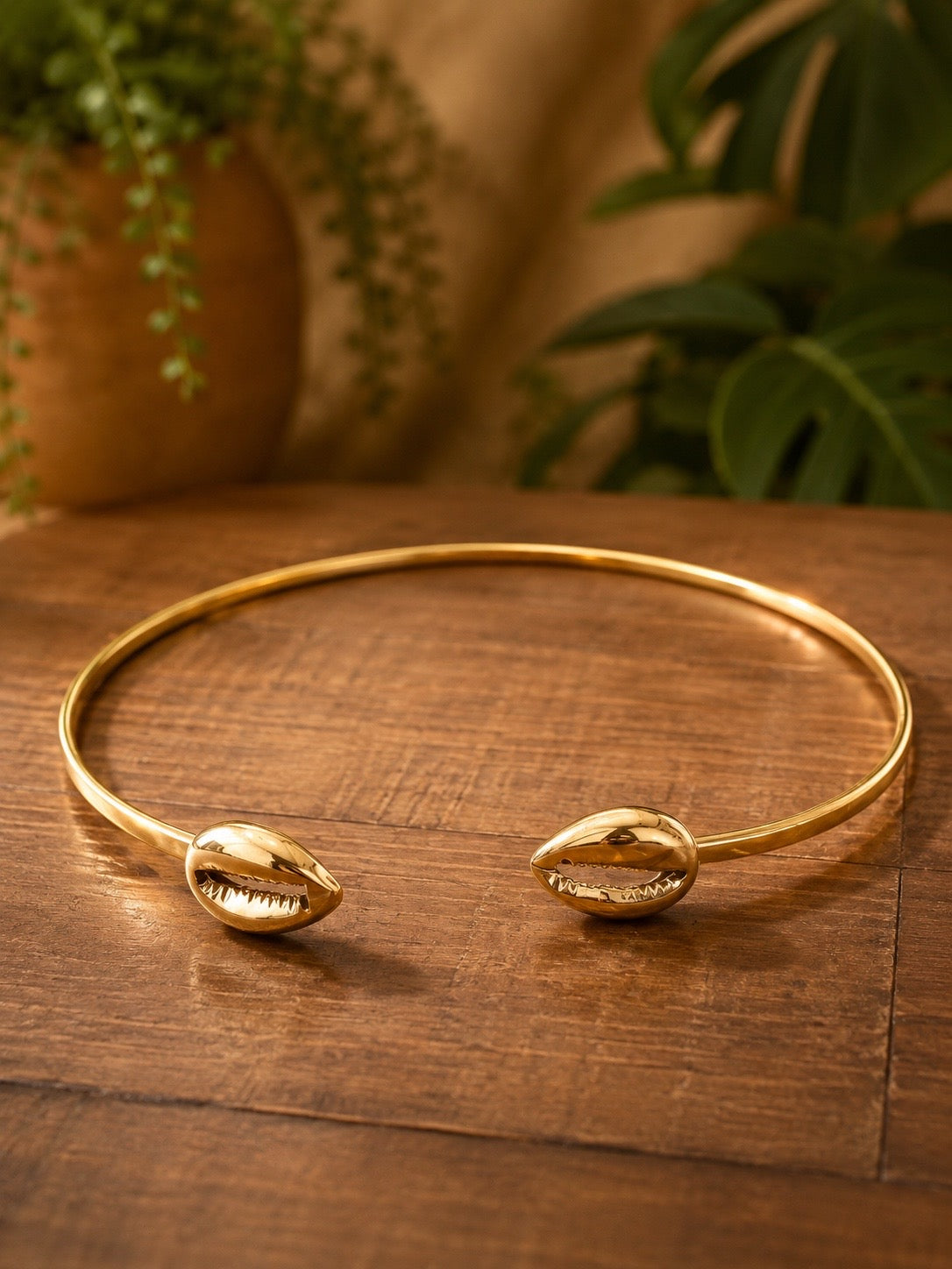 brass choker necklace  with shell designs on a wooden surface